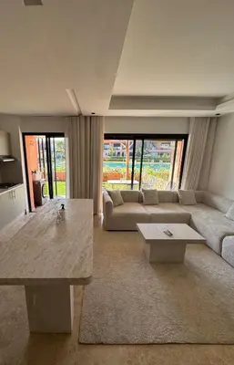 a living room with a couch and a table at Rez de Jardin T3 Piscine Noria in Marrakech