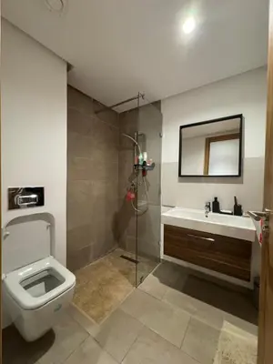 a bathroom with a toilet and a sink and a shower at Rez de Jardin T3 Piscine Noria in Marrakech