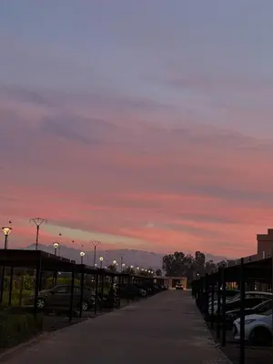 a parking lot at sunset with cars parked at Rez de Jardin T3 Piscine Noria in Marrakech