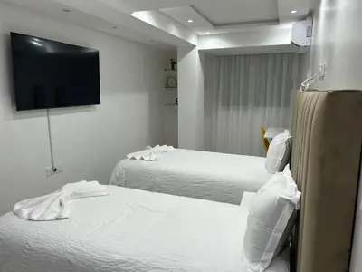 a hotel room with two beds and a flat screen tv at Duplex 3 chambres centre ville in Marrakech