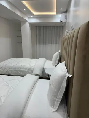 a bedroom with two beds with white sheets and pillows at Duplex 3 chambres centre ville in Marrakech