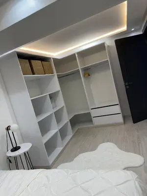 a bedroom with a white bed and a black closet at Duplex 3 chambres centre ville in Marrakech