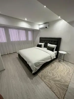 a bedroom with a large bed and a table at Duplex 3 chambres centre ville in Marrakech