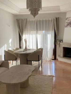 a living room with a table and chairs and a chandelier at Peaceful heaven in Marrakech