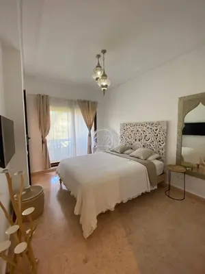 a white bedroom with a bed and a television at Peaceful heaven in Marrakech