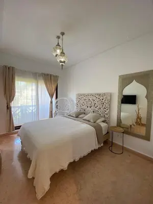 a white bedroom with a large bed and a mirror at Peaceful heaven in Marrakech