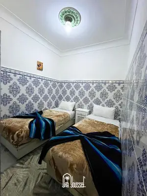 two beds in a room with blue and white wallpaper at Daryussef 114 in Marrakech
