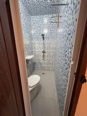 a bathroom with a toilet and a shower with blue tiles at Daryussef 114 in Marrakech