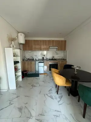 a kitchen with a marble floor and a table and chairs at chiimappart in Marrakech