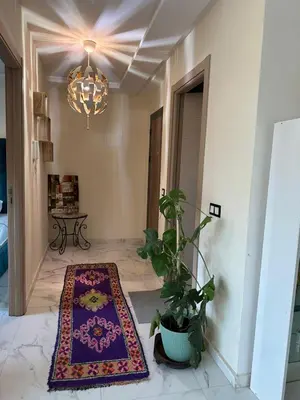a hallway with a rug on the floor and a chandelier at chiimappart in Marrakech