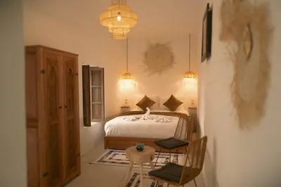 a bedroom with a bed and a table and chairs at Riad julines in Marrakech