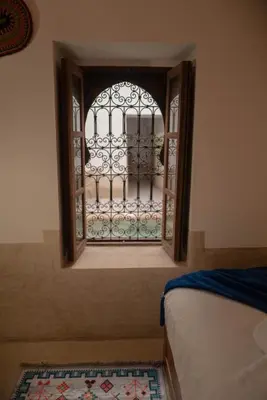 a window with a gate in a room with a rug at Riad julines in Marrakech