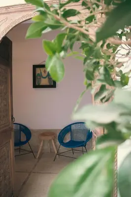 a room with three blue chairs and a table at Riad julines in Marrakech