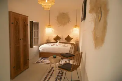 a bedroom with a bed with two chairs and a table at Riad julines in Marrakech