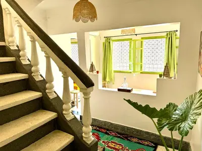 a stairway with green curtains and a mirror at Maison au cœur de Marrakech in Marrakech