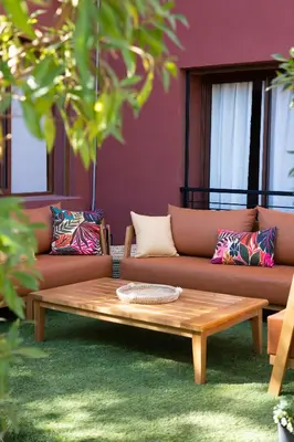 a coffee table in front of a couch with pillows at Beldi garden - appartement avec jardin et gouvernante in Marrakech