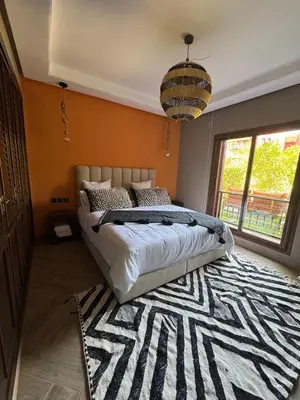 a bedroom with a large bed and a rug at Beldi garden - appartement avec jardin et gouvernante in Marrakech