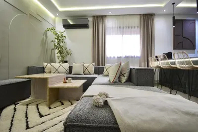 a living room with a couch and a table at Appartement Cosy et Moderne Accès 4 piscines in Marrakech