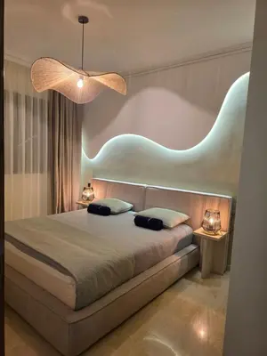 a bedroom with a large bed with a blue headboard at Appartement Cosy et Moderne Accès 4 piscines in Marrakech