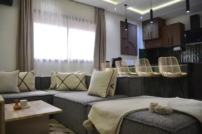 a living room with couches and chairs and a window at Appartement Cosy et Moderne Accès 4 piscines in Marrakech