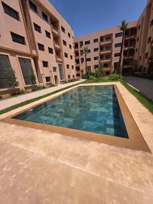 a swimming pool in front of a building at Appartement Cosy et Moderne Accès 4 piscines in Marrakech
