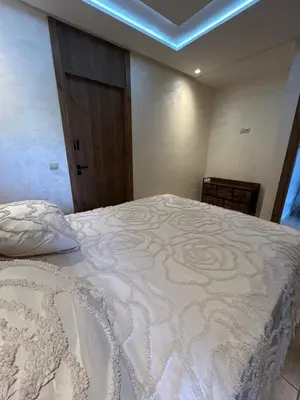 a bedroom with a bed with a white comforter at Apartment proche gueliz in Marrakech