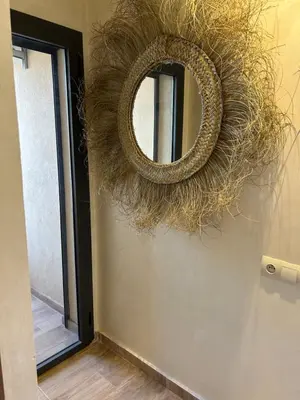 a wreath on a wall with a mirror on it at Apartment proche gueliz in Marrakech