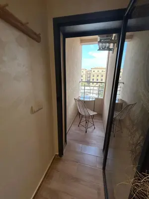 a door to a balcony with chairs and a table at Apartment proche gueliz in Marrakech