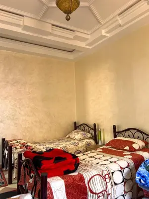 a bedroom with two beds and a ceiling at Moroccan culture Apt! Airport in Marrakech