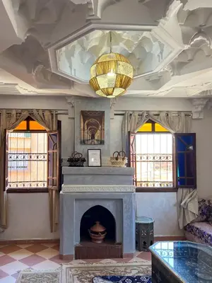 a living room with a fireplace and a chandelier at Moroccan culture Apt! Airport in Marrakech
