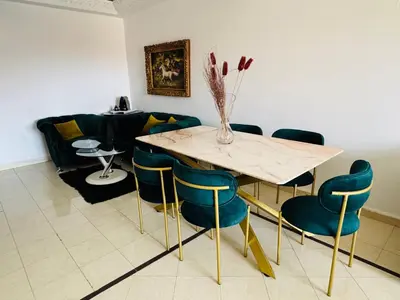 a dining room with a table and chairs and a couch at chic nest heart of gueliz With pool in Marrakech