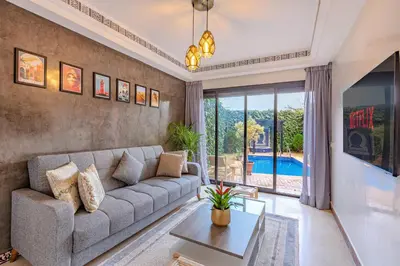 a living room with a couch and a table at Magnifique Duplex avec piscine privée in Marrakech