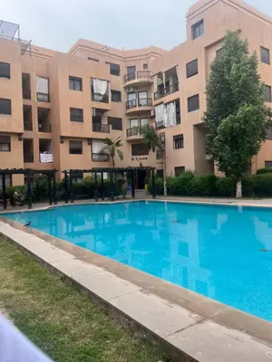 an empty swimming pool in front of a building at Magnifique Duplex avec piscine privée in Marrakech