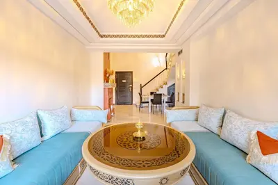 a living room with a blue couch and a table at Magnifique Duplex avec piscine privée in Marrakech
