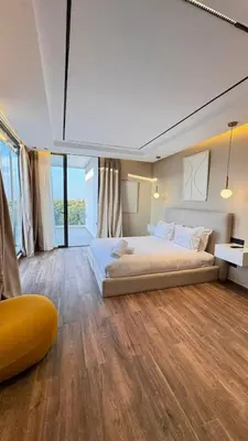 a large bedroom with two beds and a large window at villa Argan, Confort & Modern avec PiscineChauffée in Marrakech