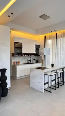 a kitchen with white cabinets and a table with chairs at villa Argan, Confort & Modern avec PiscineChauffée in Marrakech