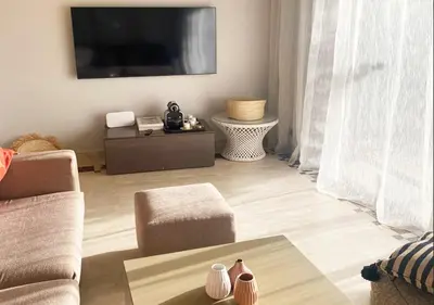 a living room with a flat screen tv on the wall at Luxueuse Appart Vizir 106 in Marrakech