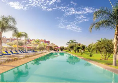 a large swimming pool with chairs and palm trees at Luxueuse Appart Vizir 106 in Marrakech