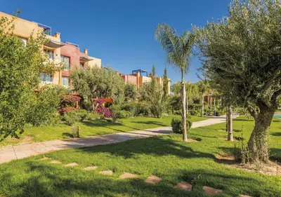 a park with palm trees and a building at Luxueuse Appart Vizir 106 in Marrakech