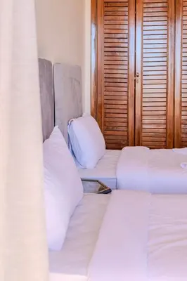 two beds in a room with white sheets and pillows at Luxury 2BR with Pool & Garden View Balcony in Marrakech
