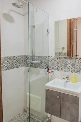 a bathroom with a glass shower and a sink at Luxury 2BR with Pool & Garden View Balcony in Marrakech