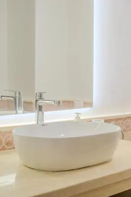 a white sink on a wooden counter in a bathroom at Luxury 2BR with Pool & Garden View Balcony in Marrakech