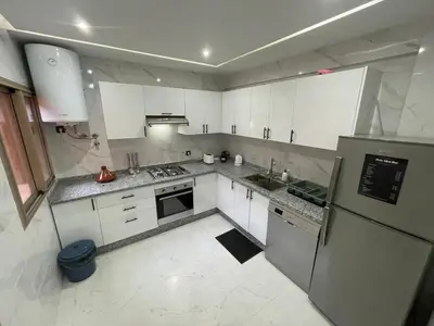a kitchen with white cabinets and a refrigerator at Modern Stay 3 bedroom City Center with Balcony in Marrakech