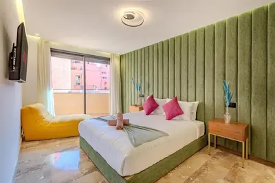 a bedroom with a large bed and a yellow chair at Large elegant 2BR Apt in Gueliz in Marrakech