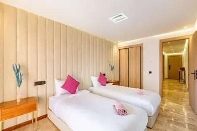 two beds in a room with pink pillows at Large elegant 2BR Apt in Gueliz in Marrakech