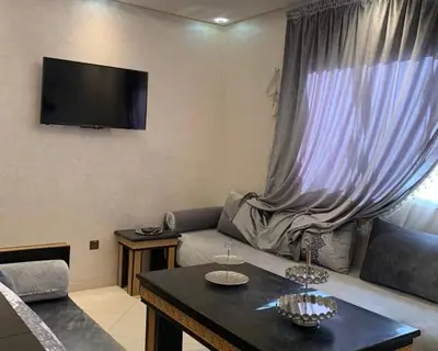 a living room with a couch and a tv on the wall at well-equipped apartment in Marrakech