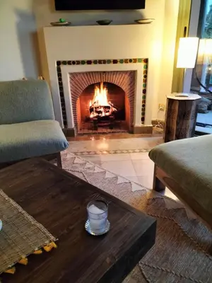 a living room with a fireplace and a coffee table at Marrakech Palmeraie 2 appartement 3 ch 7 pers résidence avec piscine in Marrakech