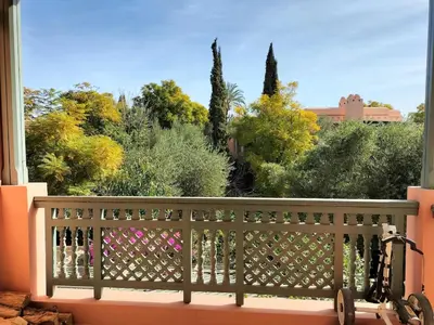 a balcony with a view of trees and bushes at Marrakech Palmeraie 2 appartement 3 ch 7 pers résidence avec piscine in Marrakech