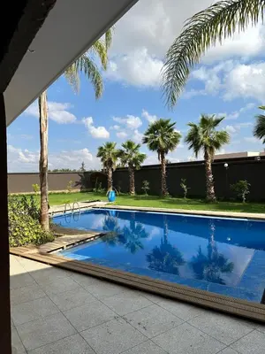 a swimming pool with palm trees in the background at Villa akiba in Marrakech