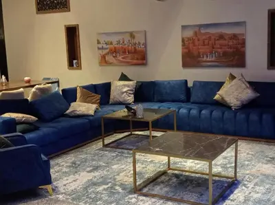 a living room with a blue couch and a table at Villa akiba in Marrakech
